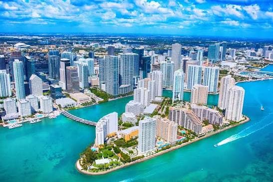 Miami towers from the air, ringed by turquoise water